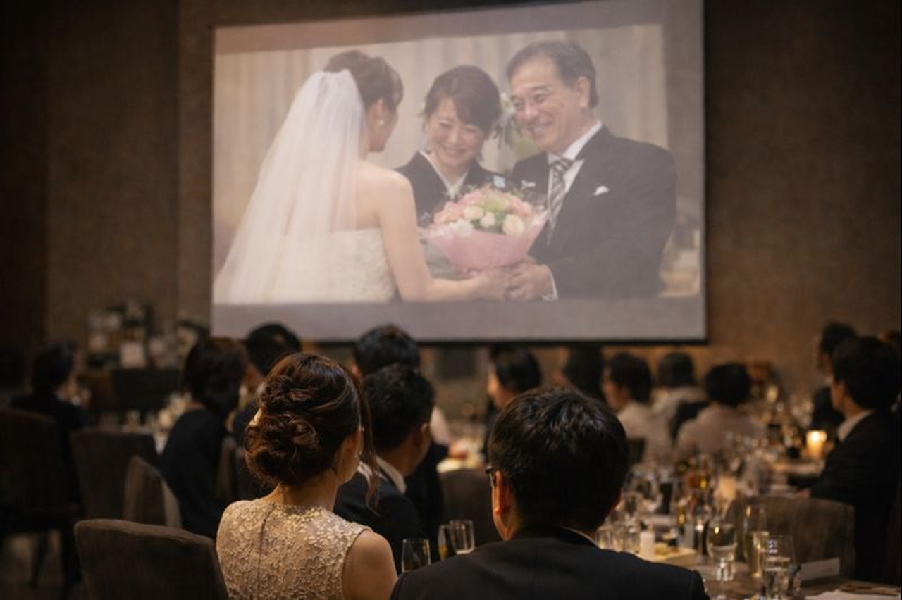 スクリーンに写った花束贈呈のシーン