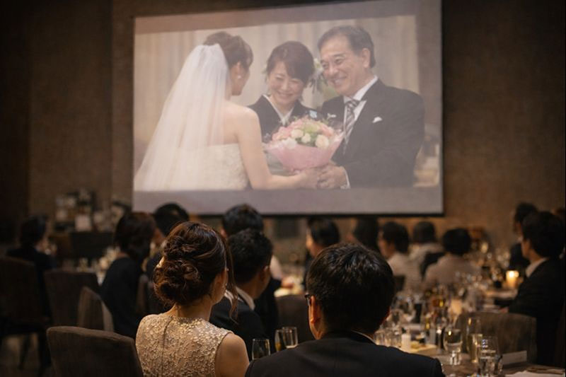 スクリーンに写った花束贈呈のシーン